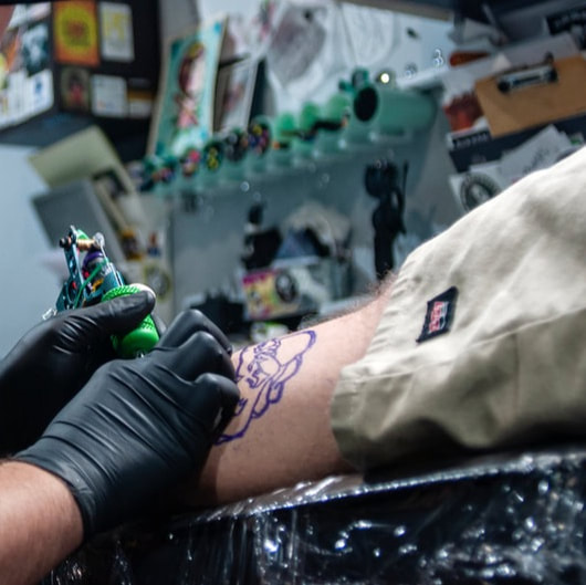 Tattoo artist creating a custom design at Ink Parlor KC